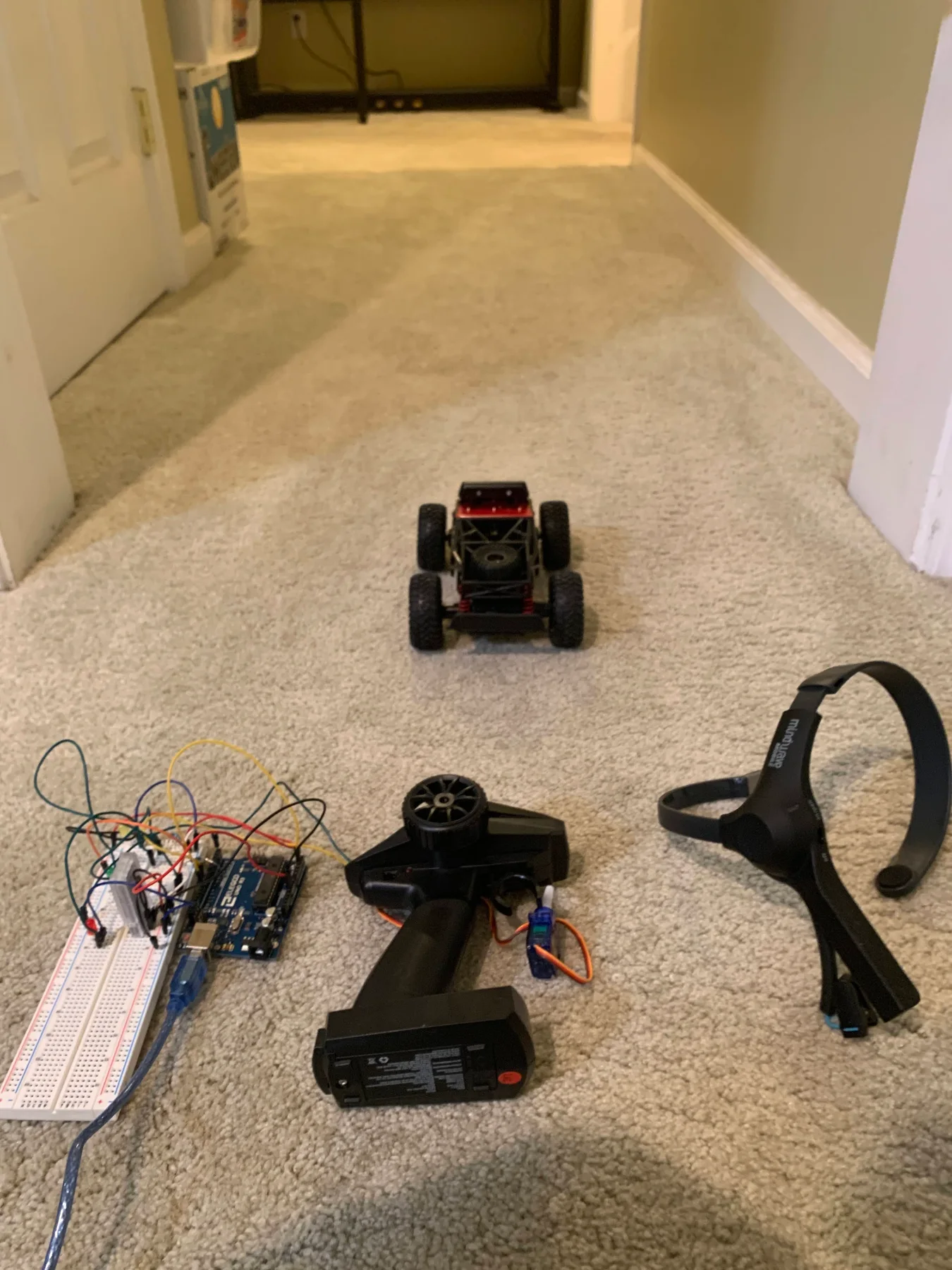 Complete RC-car control setup with MindWave headset, Arduino, breadboard, and a servo attached to the remote