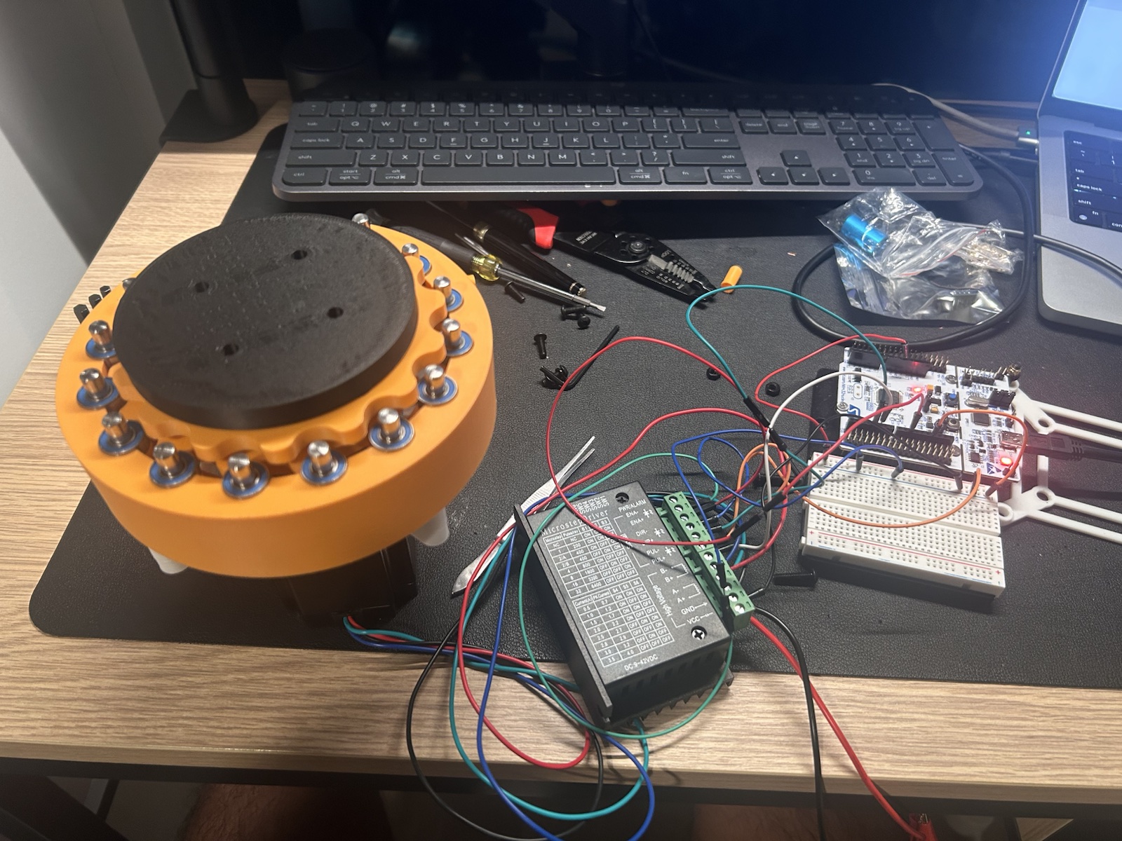 3D-printed cycloidal actuator connected to its stepper driver and development electronics on a workbench